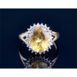 A 9ct yellow gold, diamond and yellow (golden) beryl ring set with an oval-cut yellow beryl of