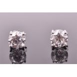 A large pair of 18ct white gold and solitaire diamond stud earrings set with round brilliant cut