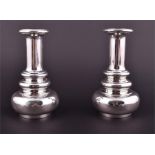 A pair of Anthony Elson candlesticks London 1980, each cylindrical column terminating in stylised