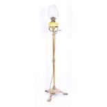 A Victorian brass standard lamp (electrified) the column stem supported on a shaped tripod base,