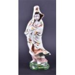 A late 19th/early 20th century Chinese ceramic figure of GuanYin depicted in a cloak with hand