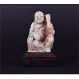 A finely detailed Chinese carved soapstone figure of a seated Buddha  seated and listening in