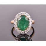 An 18ct yellow gold, diamond, and emerald cluster ring the oval cut emerald of approximately 3.20