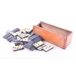 A set of twenty-eight bone and ebony dominoes boxed, domino size 4 x 2 cm.  CONDITION REPORT Some