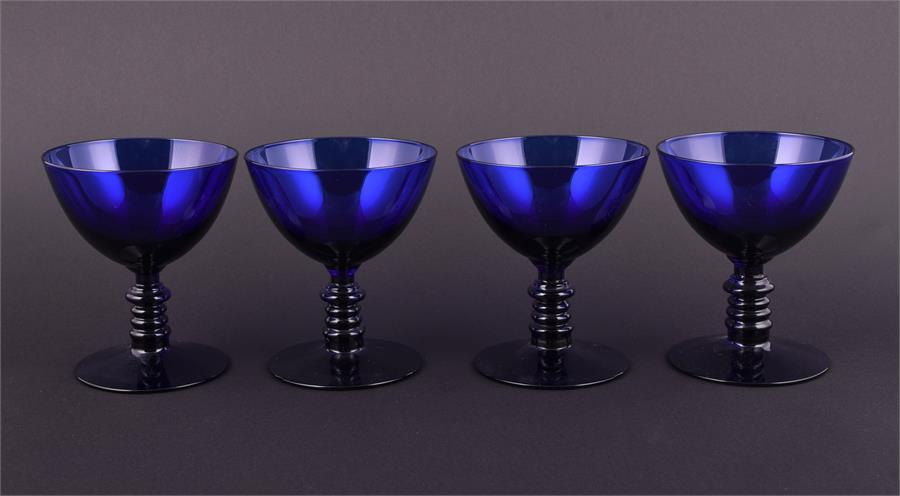 A set of four cobalt blue drinking glasses of circular form with ribbed stems, 9.5 cm high.
