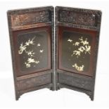 A Meiji period Japanese lacquered wood two-division screen with carved decoration of birds amongst