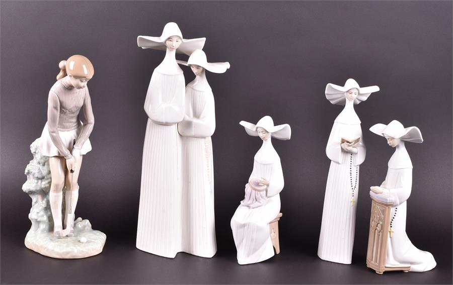 A collection of five Lladro figures to include four nuns and a female golfer, all boxed