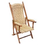 A Victorian folding campaign chair with upholstered back, seat and arms with turned supports.