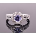 An 18ct white gold, diamond, and tanzanite halo ring set with a central round cut tanzanite,