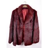 A maroon-coloured rabbit fur half-length ladies jacket with long sleeves, maroon-coloured satin