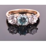 A 9ct yellow gold, white and blue topaz ring set with a round cut turquoise-blue topaz flanked by