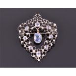 A white metal and sapphire pendant/brooch suspended with a yellow metal mounted cushion-cut sapphire