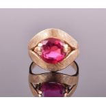 An 18ct yellow gold and red stone (possibly ruby) ring claw-set with a red stone in open split