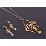 An Edwardian 9ct yellow gold, peridot, and split seed pearl pendant set with two round cut peridots,