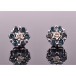 A pair of white gold, white and blue diamond floral cluster ear studs each centred with a round