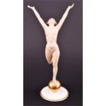 A German Hutschenreuther bisque figure of a nude woman standing on a golden orb, with leg raised and