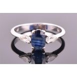 A sapphire and diamond ring, Ingle & Rhode centred with an oval mixed-cut sapphire weighing