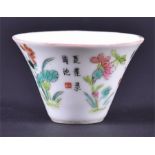 A small early 20th century Chinese porcelain wine cup hand painted and enamelled with flowers,