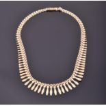 A 9ct yellow gold graduated fringed necklace in the Egyptian taste, 40 cm long, 19 grams.