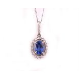 An 18ct white gold, diamond and sapphire oval halo pendant the oval-cut blue sapphire 0.50 carats,