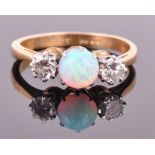 An 18ct yellow gold, diamond and opal ring set with a round cabochon opal flanked by two round