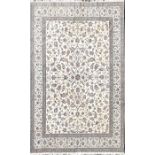 A large Persian ivory ground wool and silk Isfahan carpet decorated with a central field of