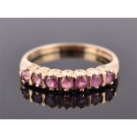 A 9ct yellow gold and ruby ring set with seven round cut rubies of approximately 0.30 carats