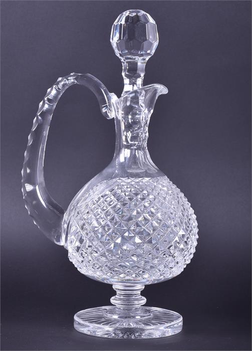 A Waterford Crystal glass decanter  with a textured handle and baluster body on a circular foot,