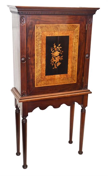 A 19th century walnut cabinet on stand the panelled door inlaid with flowers, opening to reveal a