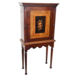 A 19th century walnut cabinet on stand the panelled door inlaid with flowers, opening to reveal a