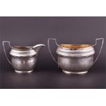 A George III silver sugar bowl and cream jug London 1802, by John Emes, each oval body with bright-