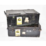 Two black painted metal travelling trunks both with carrying handles.