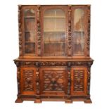 A substantial Continental oak bookcase with glazed panelled doors, supported on a dresser base