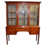 A large Edwardian mahogany bookcase the base with central drawer flanked by cupboards, supported