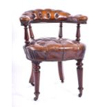 An early Victorian mahogany library armchair with richly patinated leather button back covering to