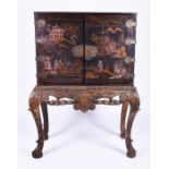 A late 19th century black lacquered chinoiserie cabinet on stand the exterior with gilded scenes