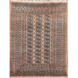 A Bokhara rug with three rows of individual medallions on a light brown ground, multi-bordered and