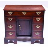 A George III mahogany kneehole desk the top with moulded rim over a long drawer with fully fitted