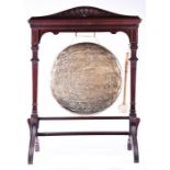 A large Victorian mahogany framed brass dinner gong together with striker, on four feet, 102 cm