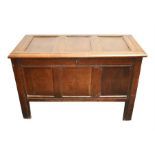 A 19th century oak chest with hinged three-panelled lid, panelled sides, raised on four straight