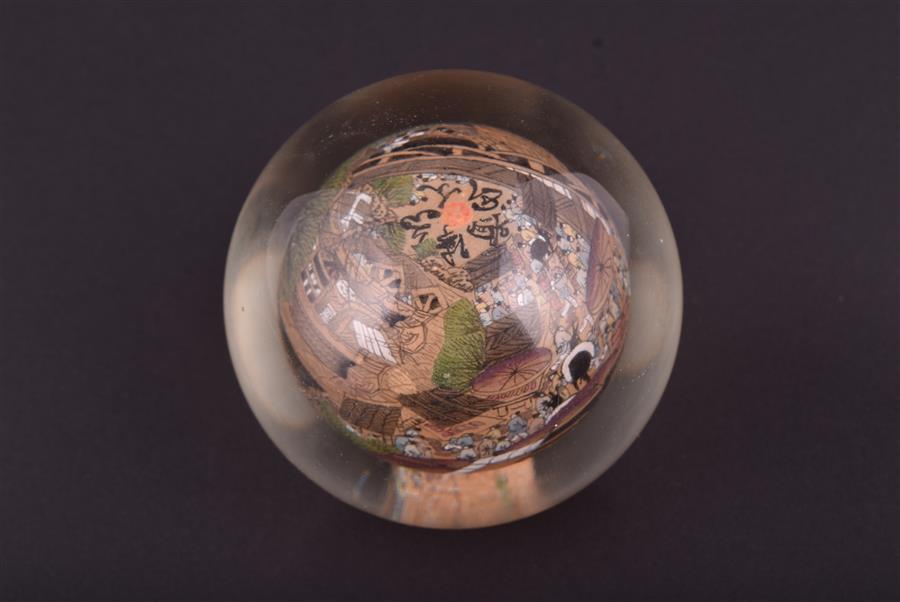 A Chinese reverse painted glass paperweight of rounded form, decorated from the inside with delicate