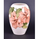 A Moorcroft cream ground ceramic vase in the Coral Hibiscus pattern of baluster form with an open