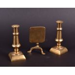 A pair of miniature brass candlesticks and a miniature brass table, 10cm. (3)