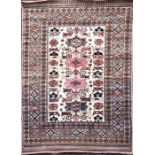 A Persian cream and iron red ground rug polychrome decorated with central rectangular frame