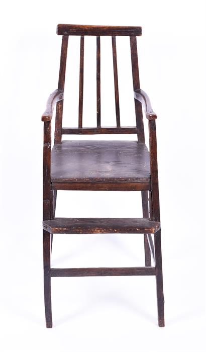 A childs 18th century elm high chair of simple naive form, the triple spindle back with open arms, - Image 4 of 4