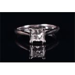 A white metal and solitaire diamond ring set with a princess cut diamond of approximately 0.50