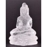 A Chinese rock crystal carving in the form of a seated Buddha the figure presented with long hair,