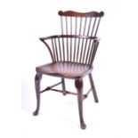 A good 18th century high comb-backed Windsor armchair the elm seat supported on swept hind legs