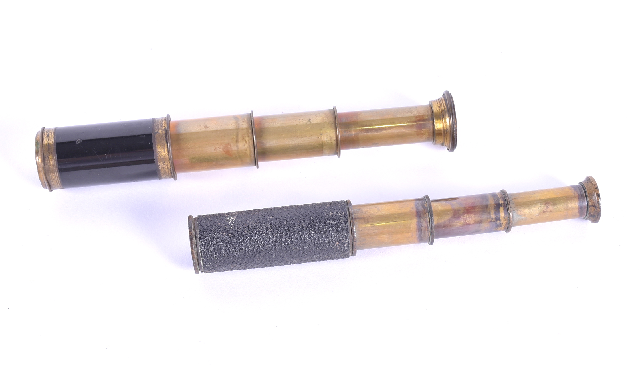 Two miniature brass telescopes each in four segments, lenses intact, one with textured body.