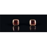 A pair of 9ct yellow gold and garnet ear studs each bezel set with a square cabochon garnet.